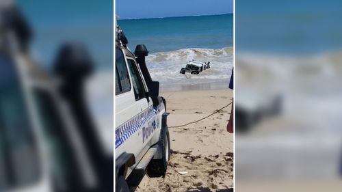 Police towing the submerged 4WD from the ocean. (Twitter)
