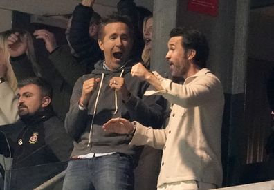 Wrexham co-owners Ryan Reynolds and Rob Mac celebrate after VAR ruled the first Wrexham goal onside.