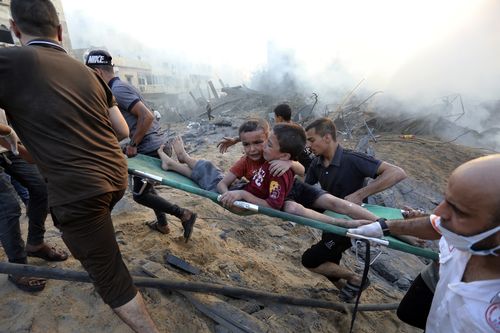 Palestinians evacuate two wounded boys out of the destruction following Israeli airstrikes on Gaza City, Wednesday, Oct. 25, 2023. 