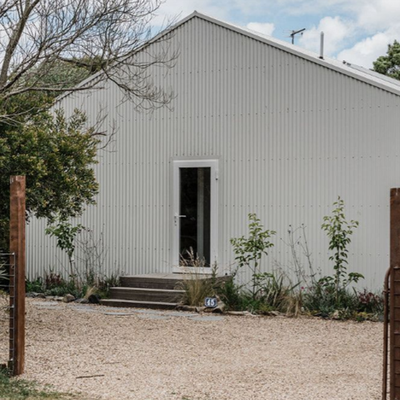 Don’t let this unassuming white shed fool you… inside lies a designer masterpiece