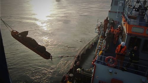 Firefighters remove a body from the Italian-flagged Euroferry Olympia, which is on fire for third day, in the Ionian Sea near the Greek island of Corfu, on Sunday, Feb. 20, 2022. A survivor has been rescued Sunday morning from the stern of a still burning passenger ferry, Greece's coast guard said. (Hellenic Fire Service via AP)