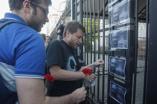 Ukrainian activists place portraits of  Babchenko on a fence of the Russian embassy in Kiev. Picture: AP