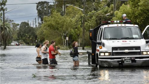 Wading through waters in San Marco get a ride from a fire department rescue truck. (AAP)