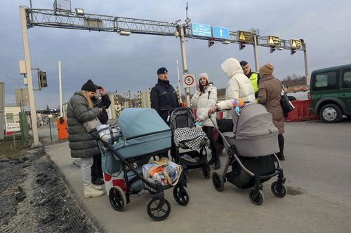 Ukranian refugees assisted by Polish border police arrive at the Medyka border crossing, Poland, Saturday, Feb. 26, 2022. (AP Photo/Visar Kryeziu)