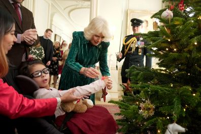 Queen Camilla and invited children, supported by Helen & Douglas House and Roald Dahl's Marvellous Children's Charity, decorate the Christmas tree and receive a few festive surprises at Clarence House on December 6, 2023 in London, England.
