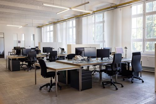 Open plan startup office.  Coworking desks in a brightly lit office space.