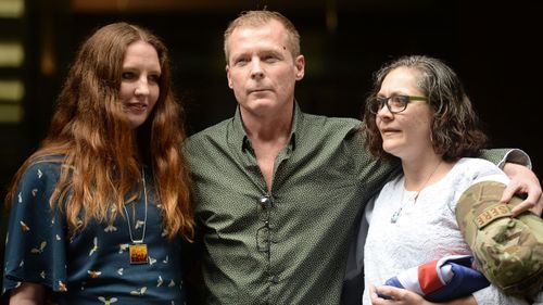 Australian academic Timothy Weeks poses for a photograph with his sisters Alyssa Carter (left) and Joanne Carter (right).
