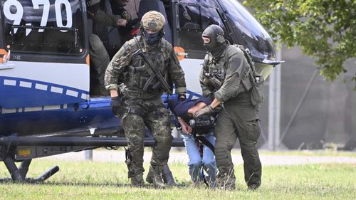 The alleged perpetrator of the knife attack in Solingen is escorted from a helicopter in Karlsruhe, Germany, Sunday, Aug. 25, 2024. 