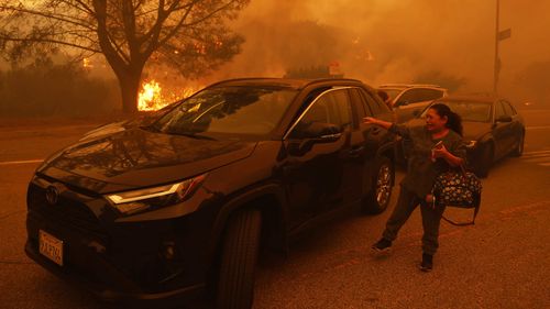 A woman cries as the Palisades Fire advances.