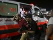 Palestinian medics help a man wounded in Israeli strikes to in Shifa Hospital in Gaza City, Friday, Oct. 13, 2023. (AP Photo/Ali Mahmoud)