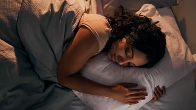 High angle shot of a beautiful young woman sleeping in her bed at home during the night