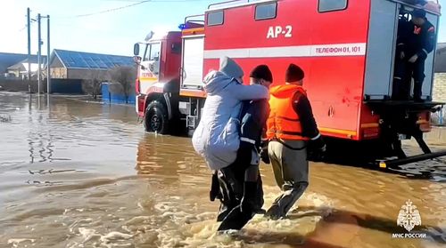 Ici, les secouristes évacuent un résident local après la rupture d'une partie d'un barrage provoquant des inondations, à Orsk, en Russie.  (Service de presse du ministère russe des Urgences via AP)