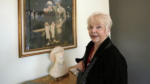 HOLD TO MOVE THURSDAY AUG 26 WITH STORY Diane Capone discusses her family near a photograph of her father, Albert Sonny Capone, as a young boy and her grandfather Al Capone on display at Witherells Auction House in Sacramento, Calif., Wednesday, Aug. 25, 2021. The granddaughter of the famous mob boss, she and her two surviving sisters will sell 174 family heirlooms at an Oct. 8 auction titled A Century of Notoriety: The Estate of Al Capone, that will be held by Witherells in Sacramento. (AP Phot