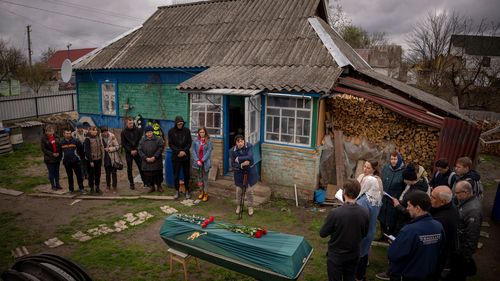 Friends and neighbours of Mykola "Kolia" Moroz, 47, gather during a funeral service at his home in the Ukrainian village of Ozera, near Bucha, on Tuesday, April 26, 2022.