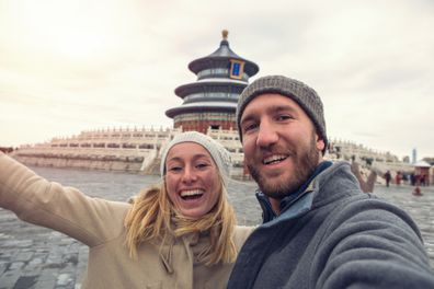 Young couple traveling take a selfie portrait with the View of the hall of prayer for good harvest of Temple of Heaven,Beijing