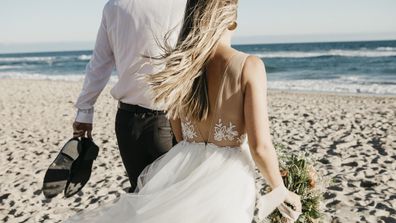 Bride and groom walking on a beach