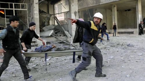 White Helmet workers carry one of the wounded civilians. (AP).