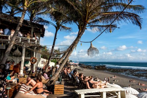 Tourists soak up the sunshine at a beach restaurant in Canggu, Bali.