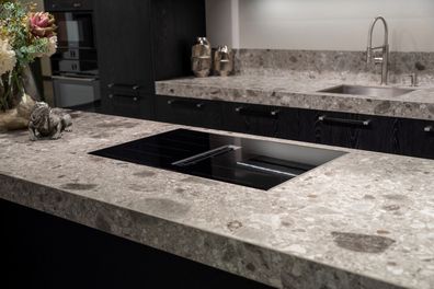 Black induction hob with built-in ventilation system on stone worktop