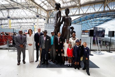 LONDON, ENGLAND - JUNE 22:  Prince William and Catherine, Duchess of Cambridge accompanied by Baroness Floella Benjamin, Windrush passengers Alford Gardner and John Richards and children pose for a picture next to the National Windrush Monument at Waterloo Station on June 22, 2022 in London, England. (Photo by John Sibley - WPA Pool/Getty Images)