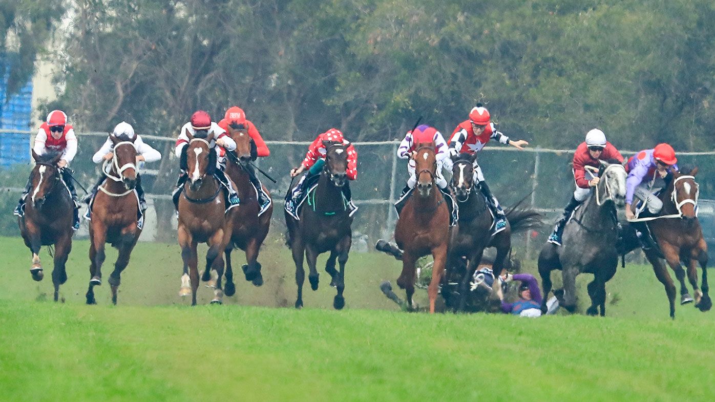 Jockey Andrew Adkins crashes to the turf during the opening race at Rosehill.