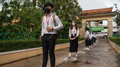 Students from a secondary school in Singapore lined up to have their vaccination records checked. 