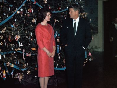 John F. Kennedy and Jackie Kennedy pose with the White House Christmas tree in 1961.