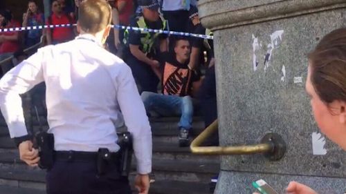 The second man being arrested at the steps in front of Flinders Street Station. (9NEWS)