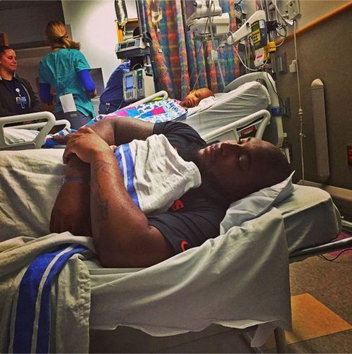 Devon Still sleeps on a hospital bed beside his daughter Leah after her latest cancer surgery. (Instagram)