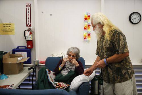 Evacuee Steve Clapper tells his mother, Euteva Bukowiecki, to wear an oxygen tube at a shelter in Pahoa. (AAP)