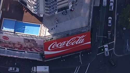 Greenpeace protesters arrested after scaling iconic Coca-Cola sign in Sydney's Kings Cross