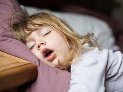 Toddler girl asleep in bed