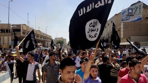 Demonstrators carry al-Qaida flags in front of the provincial government headquarters in Iraq. (AAP)