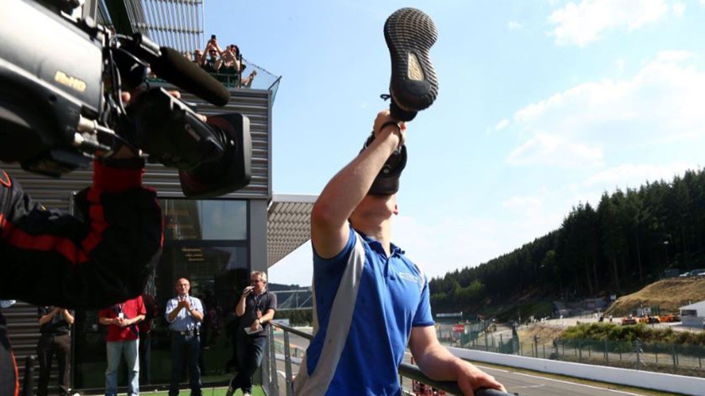 Billy Monger celebrates on the podium with a "leggy"