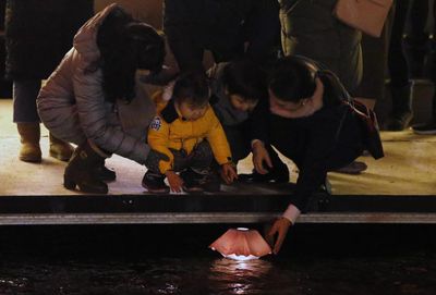People put a floating wish lamp onto water at Cheonggye street during New Year's Eve celebrations in Seoul, South Korea.