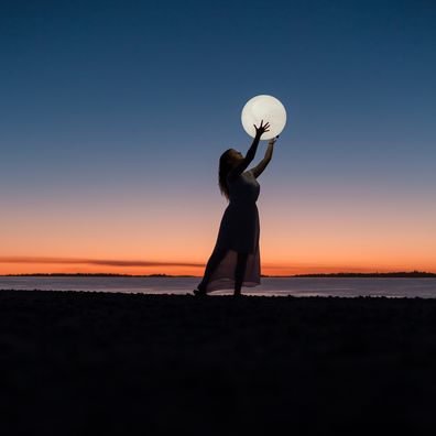 Woman embracing the full moon