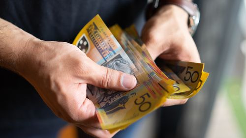 Imagem de estoque de dinheiro de pessoa segurando dinheiro australiano