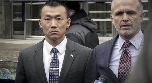 NYPD officer Baimadajie Angwang, left, a naturalized U.S. citizen born in Tibet, and his attorney John Carman, right, hold a press briefing outside Brooklyn's Federal court after a judge dismissed spy charges against him.