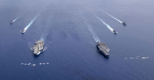 US Navy aircraft from Carrier Air Wing 5 and Carrier Air Wing 17 fly in formation over the Nimitz Carrier Strike Force (CSF). 