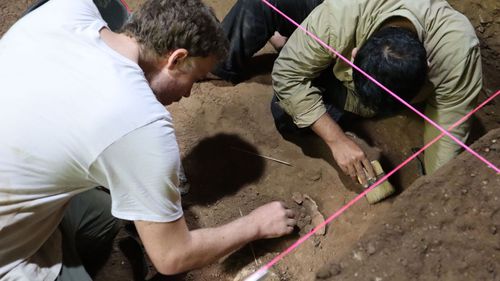Andika Priyatno from Balai Pelestarian Cagar Budaya and Dr Tim Maloney from Griffith University excavate the remains.