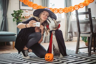 Woman and her pet dog in Halloween costumes
