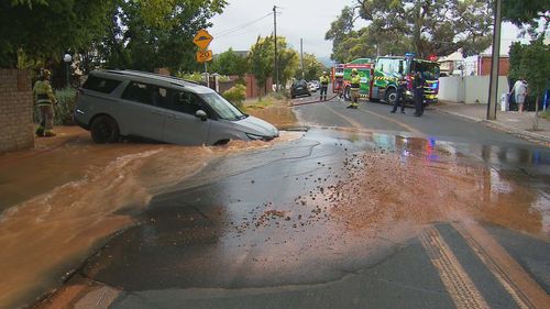 A couple's drive to the airport has taken a shocking turn after their hire car fell into a large sinkhole in Adelaide.