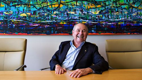 Neil Balnaves, founder of The Balnaves Foundation in front of a painting by Michael Johnson in his Sydney office. 