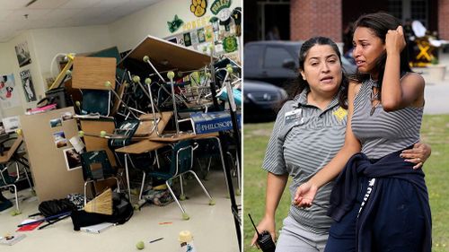 A student is comforted by a school official as students are led out of Forest High School after a shooting at the school in Ocala, Florida. (AP)