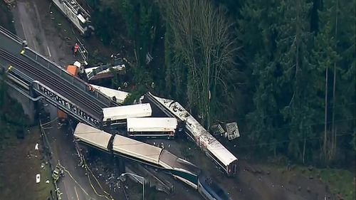 A passenger train is dangling over a motorway in the US, with fears it may be a "mass casualty incident". (AAP)