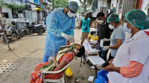 A health worker takes a nasal swab sample to test for COVID-19 in Ahmedabad, India.