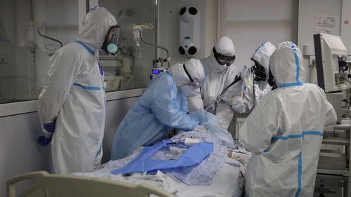 Medics wearing special suits to protect against coronavirus treat a patient with coronavirus at an ICU in Krasnodar, Russia.
