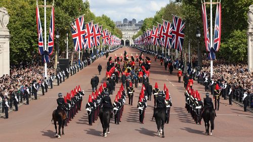 Members of the armed forces help carry the coffin of Queen Elizabeth II, adorned with a Royal Standard and the Imperial State Crown and pulled by a Gun Carriage of The King's Troop Royal Horse Artillery, during  a procession from Buckingham Palace to Westminster Hall in London, Wednesday, Sept. 14, 2022. The Queen will lie in state in Westminster Hall for four full days before her funeral on Monday Sept. 19. (Owen Cooban/Ministry of Defense via AP)