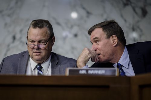 Senator Jon Tester, left, at a US Senate hearing. A spokesman said he didn't like the poster.