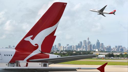 "Sydney, Australia - March, 14th 2012: Qantas aeroplanes and tail fin with the distant view of downtown Sydney - Sydney Airport"